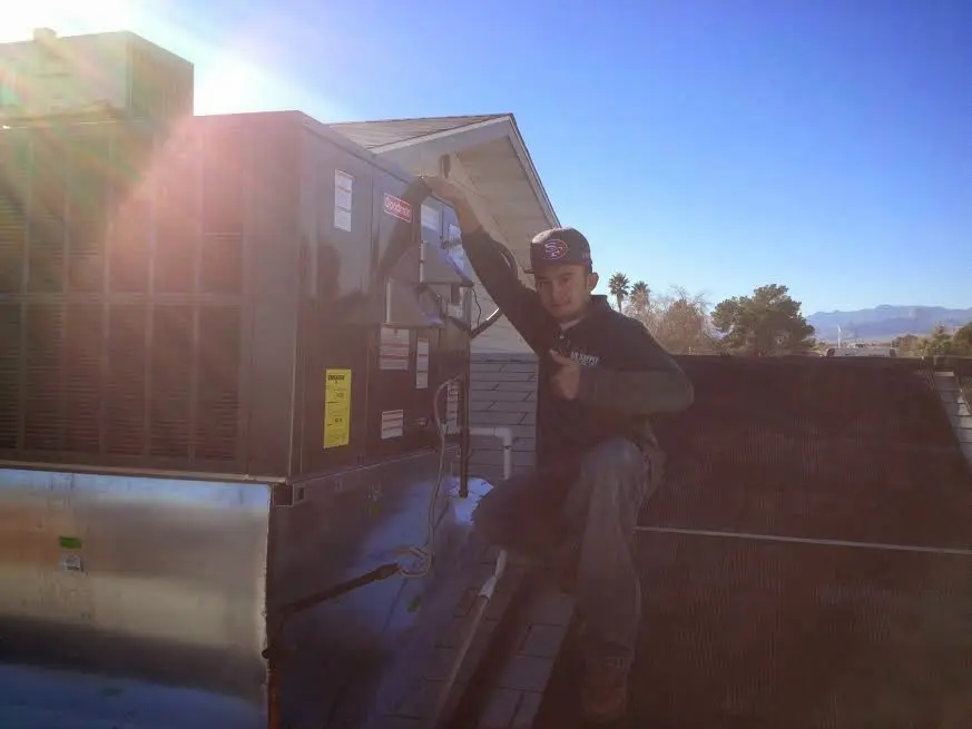 HVAC technician performing Air Duct Repair on a rooftop unit in Greeneville